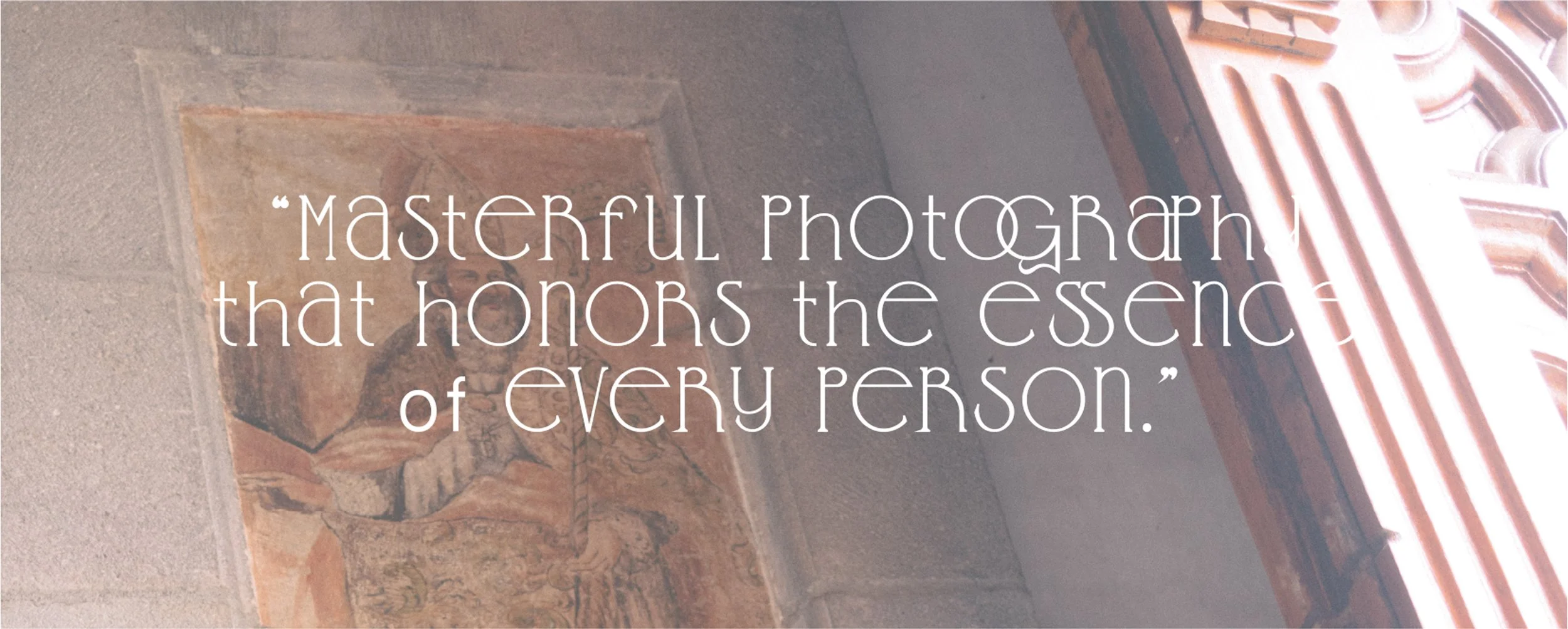 Frase en letra blanca sobre una imagen de una pintura antigua en una pared de piedra, que dice: "Masterful photography that honors the essence of every person."