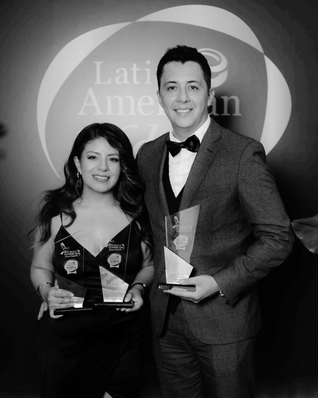 Hombre y mujer con premios en ceremonia de reconocimiento de la Asociación Latinoamericana