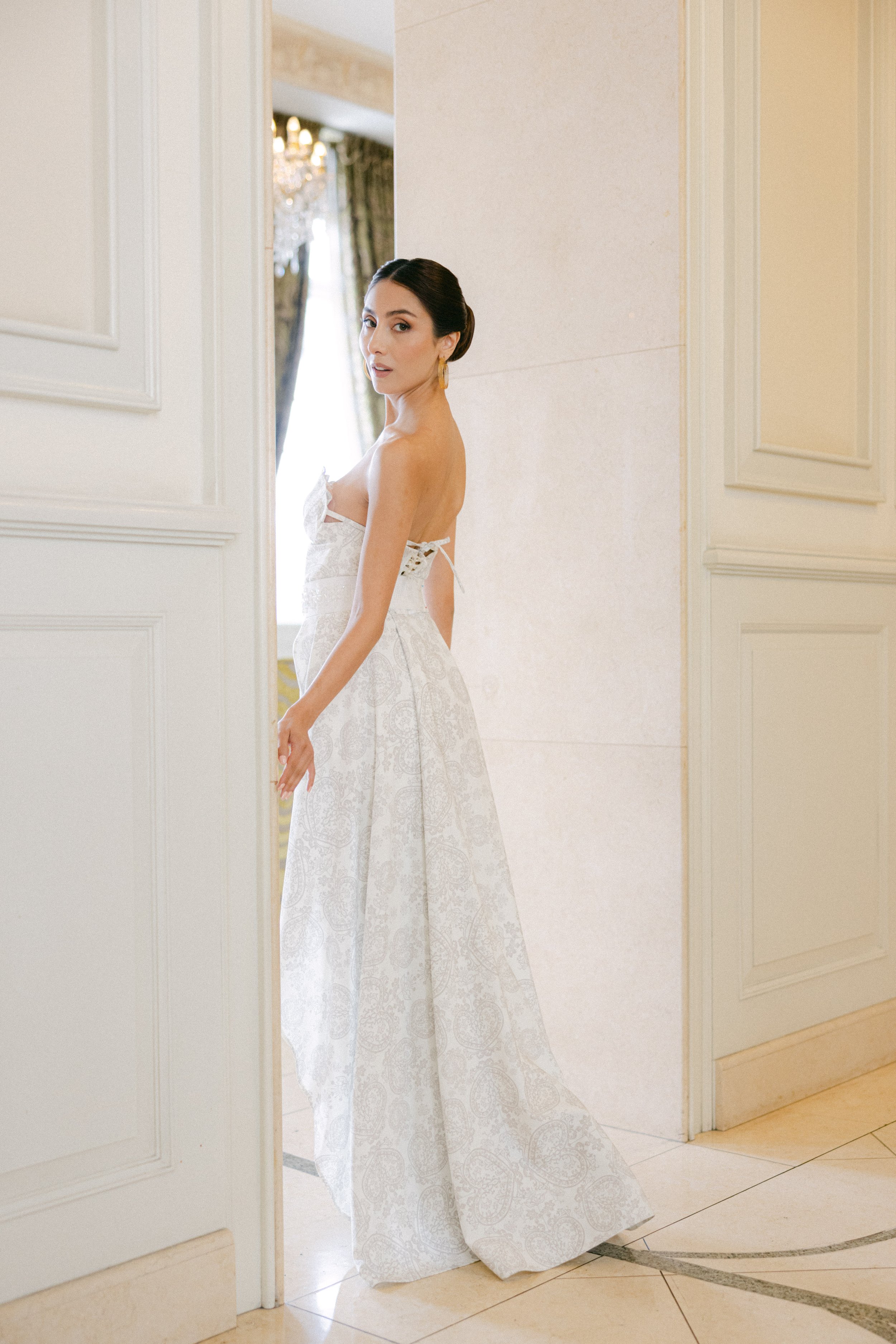 Mujer en vestido de novia en una habitación elegante.