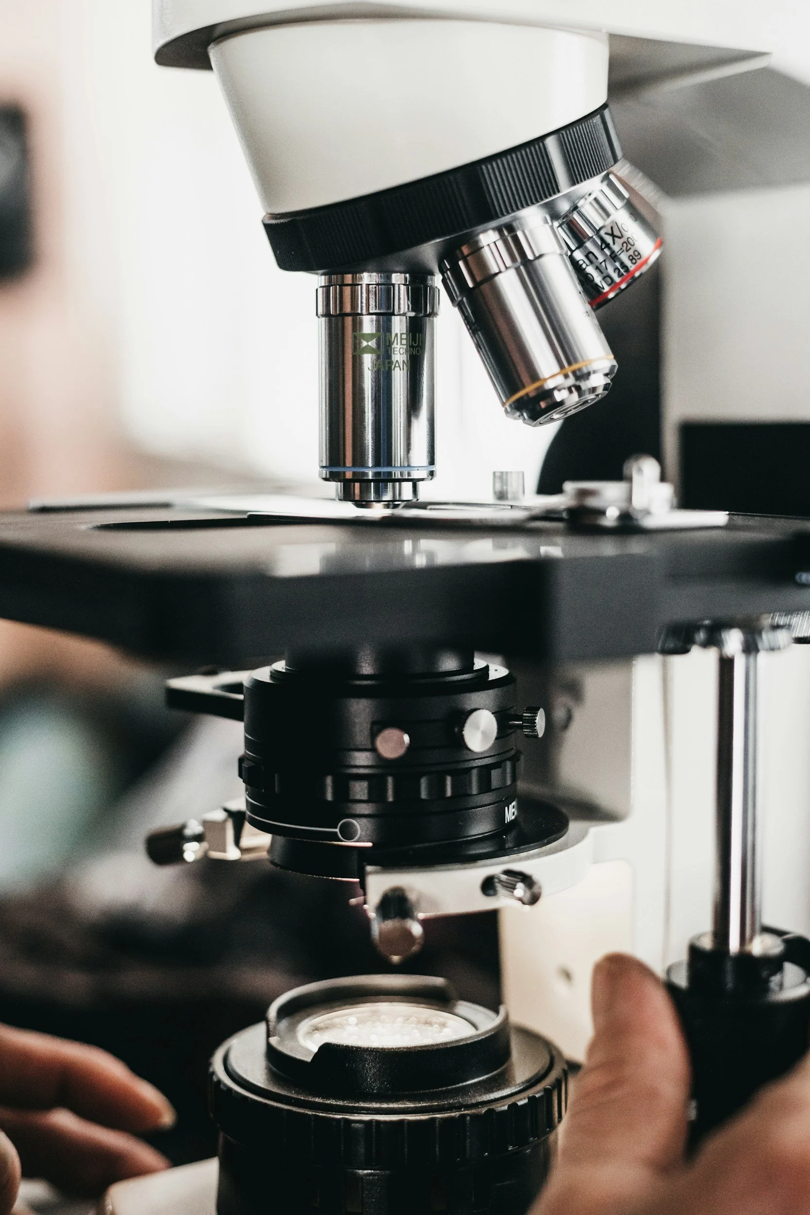 A microscope on a workbench, viewed close up.