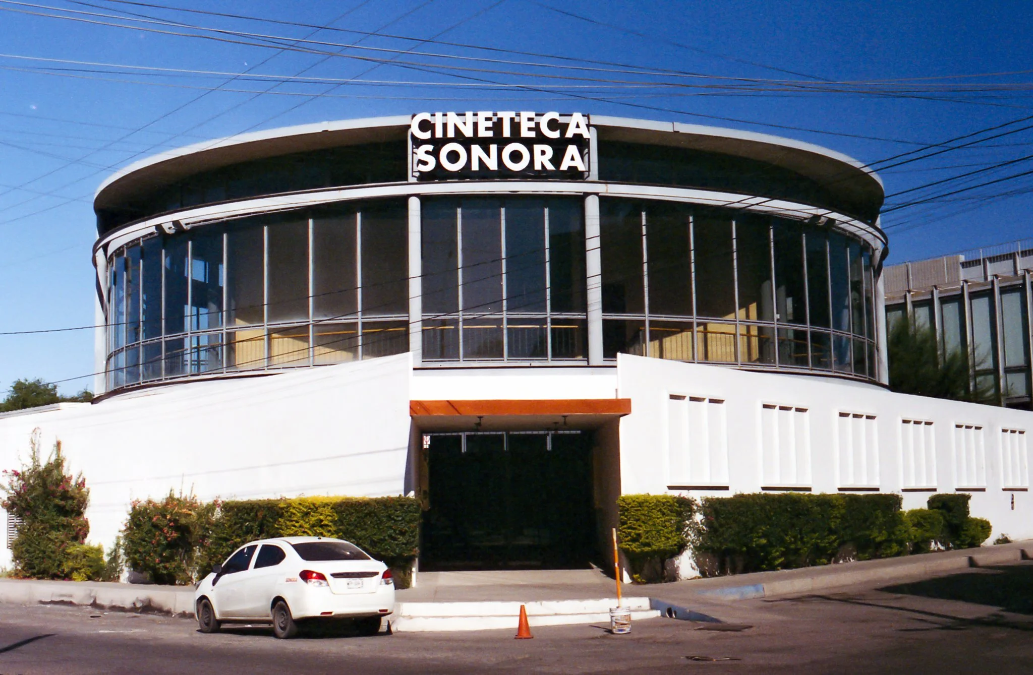 Edificio moderno con fachada de cristal y señal que dice 'Cineteca Sonora'