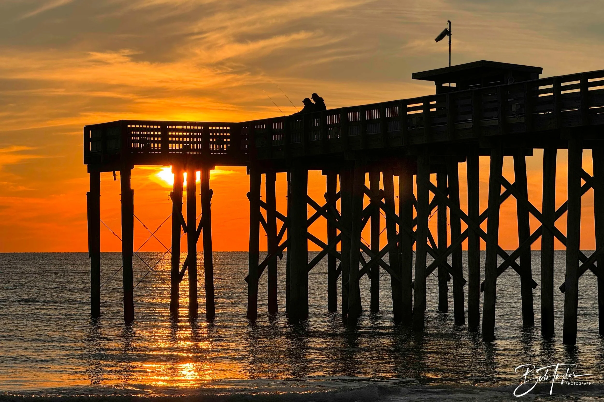 Photo of St Andrews State Park pier silhouetted at sunset 