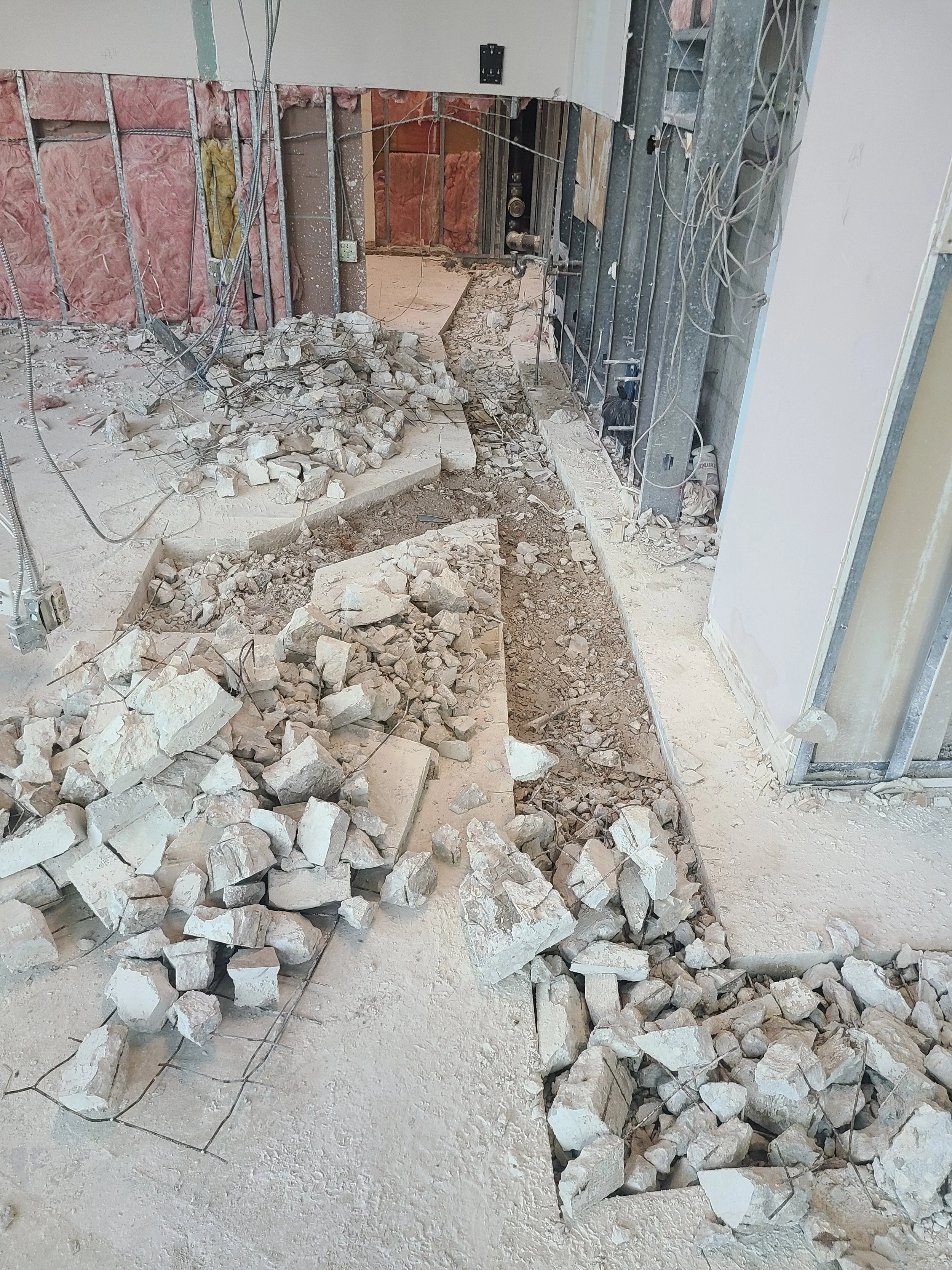 Concrete removal into adjoining space for new toilets and showers.