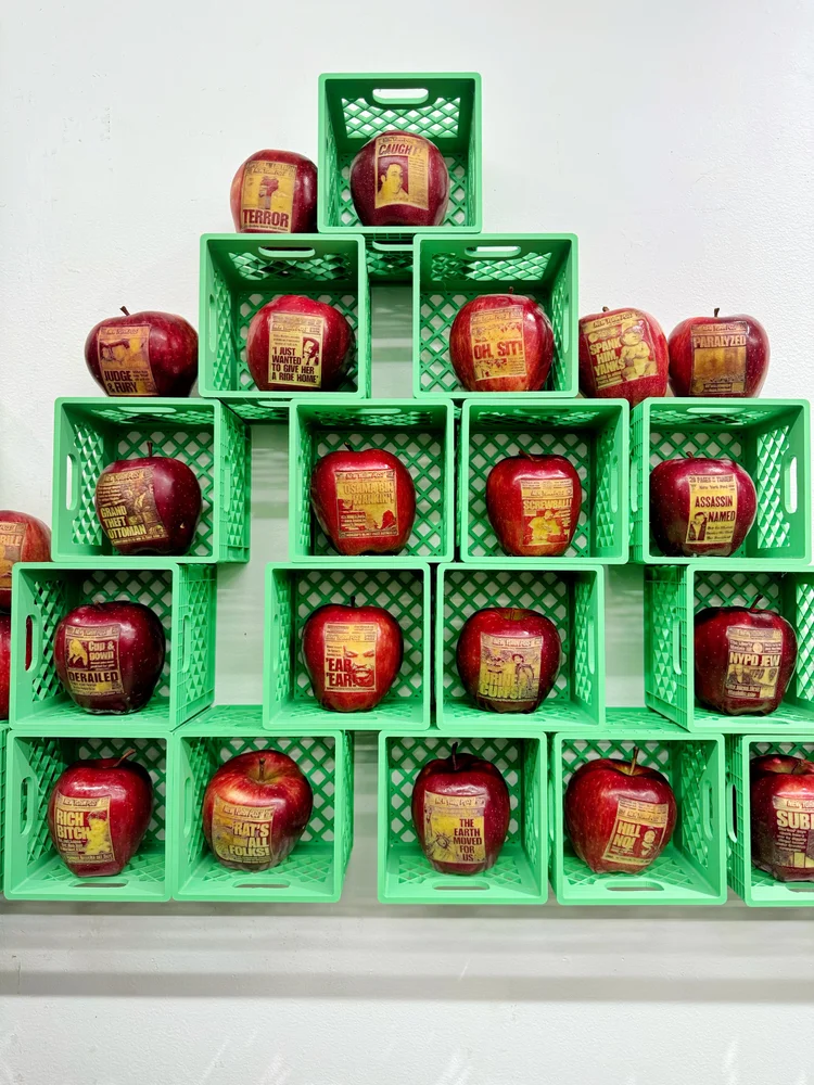 Pyramid of labeled red apples in green baskets at the Apple Stand exhibition