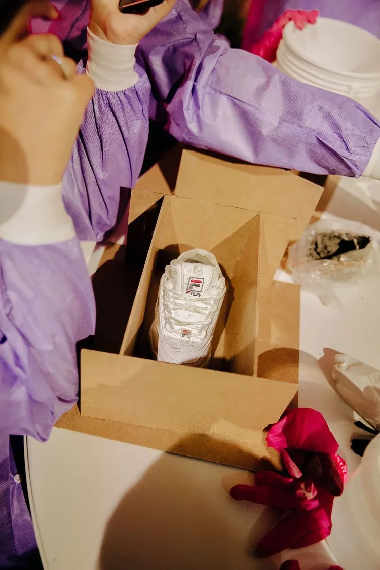 Packing a white FILA sneaker into a box