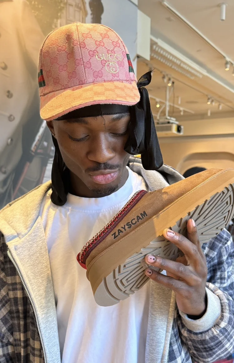 Guest examining a custom engraved sneaker at an UGG customization pop-up