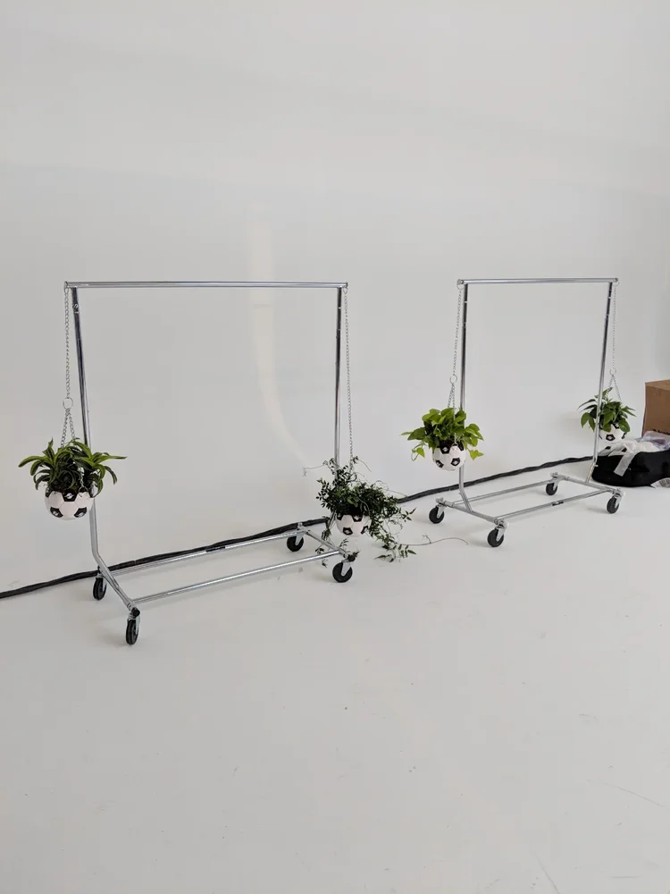 Soccer ball planters hanging from clothing racks backstage