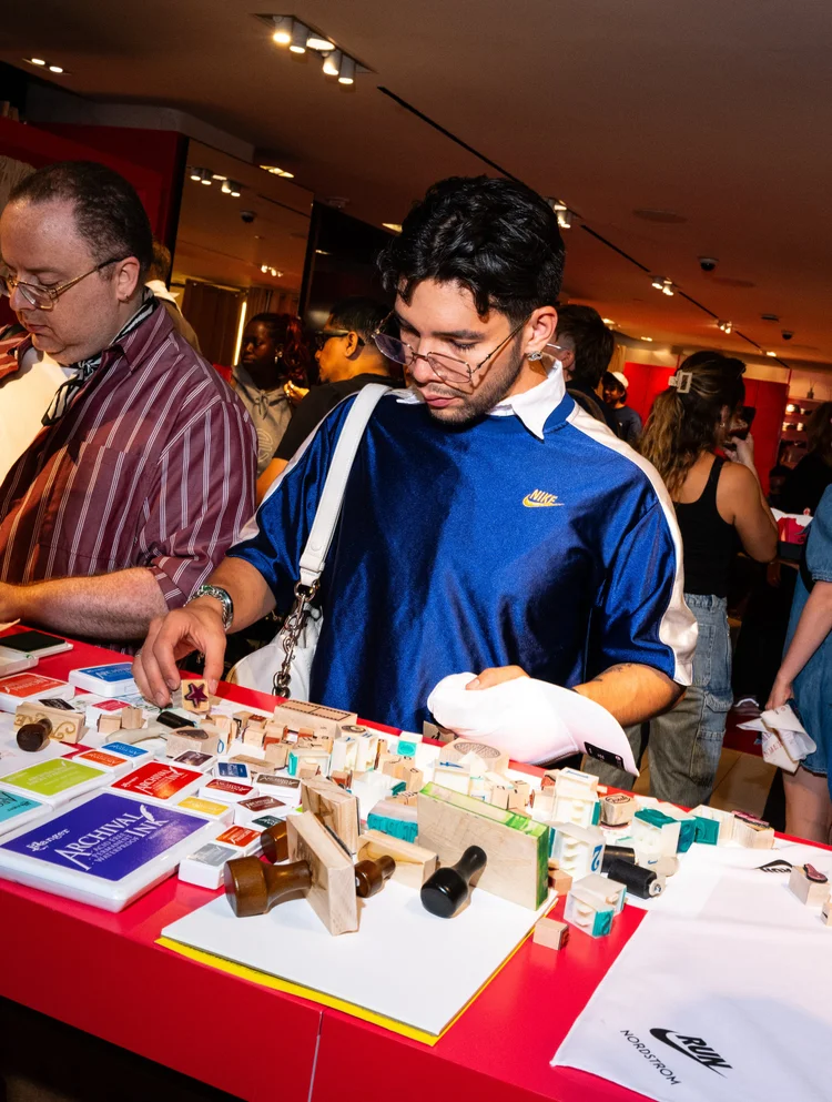 Guests browsing rubber stamps and ink pads at the live stamping event in New York