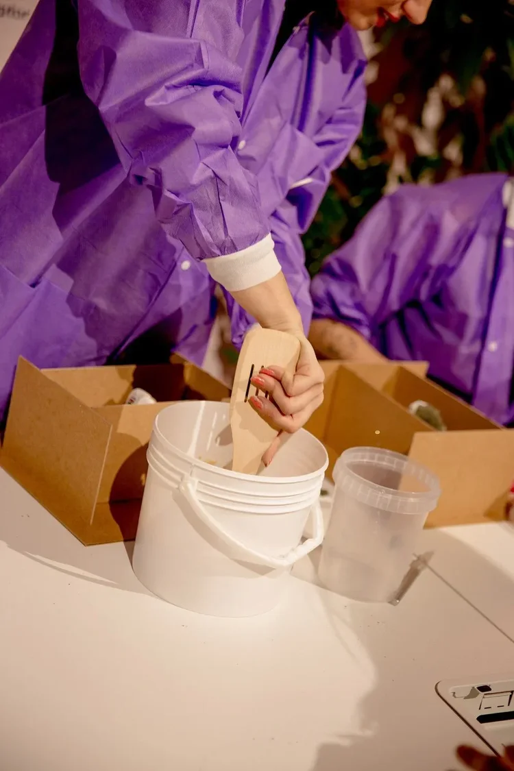 Stirring clay in a bucket during the session