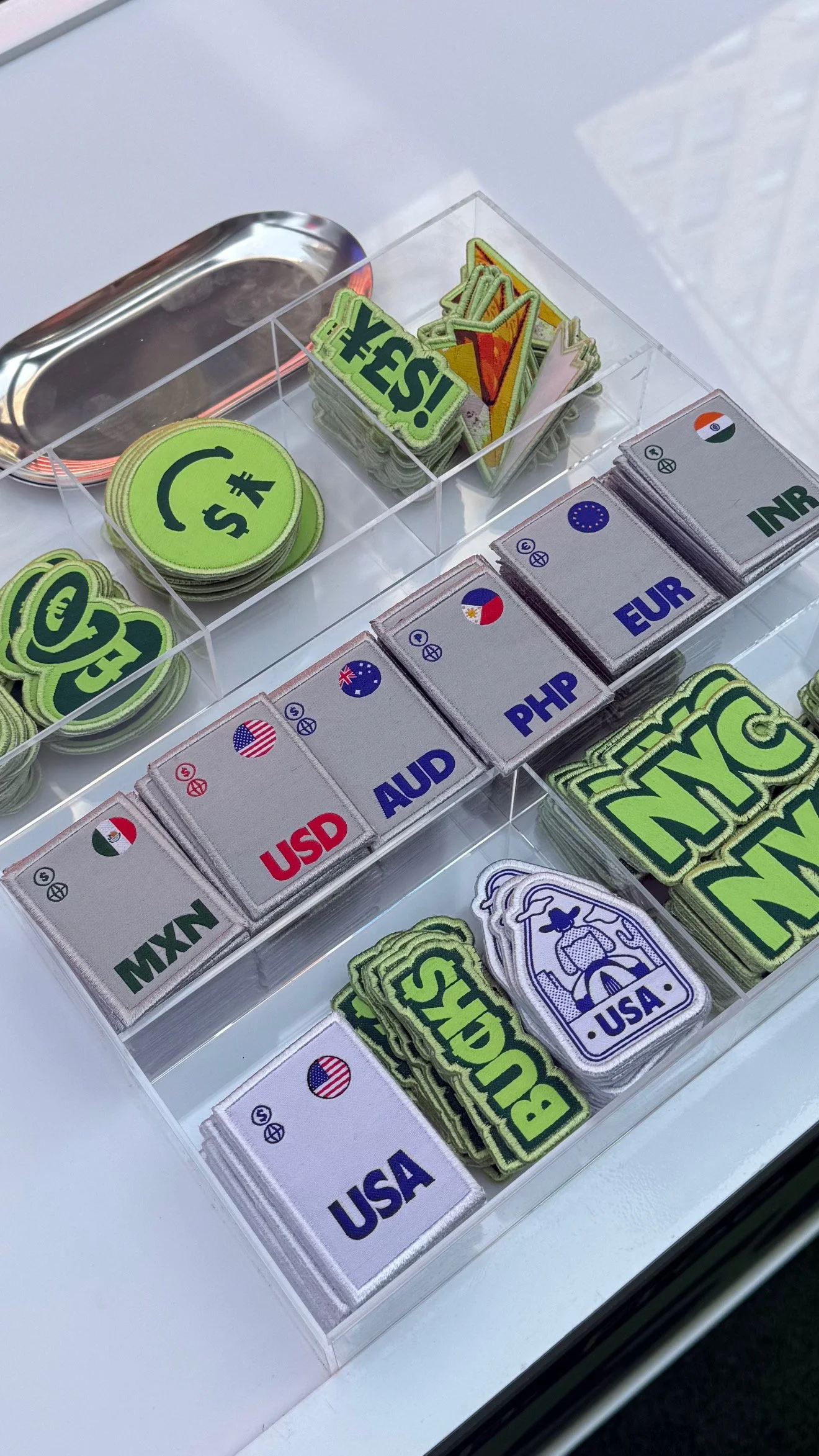 Currency patches on tote bags at the Wise IPO patch bar in Times Square