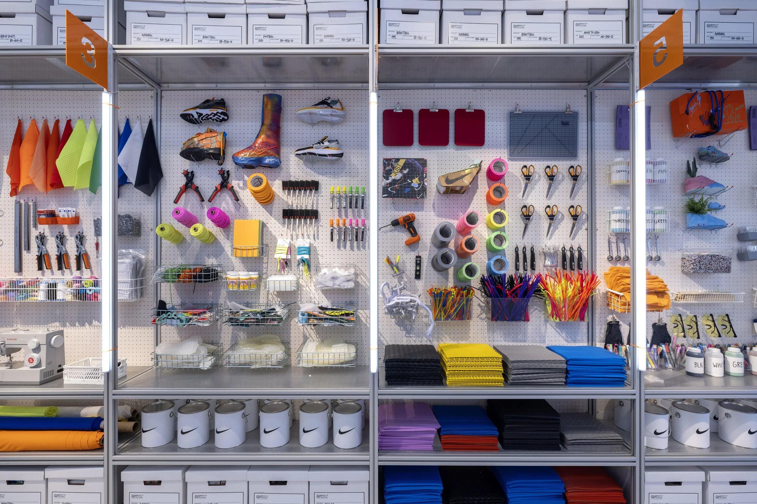 A display of sports and athletic equipment organized on a pegboard and shelves, including shoes, shoelaces, scissors, tape, towels, and various athletic accessories.