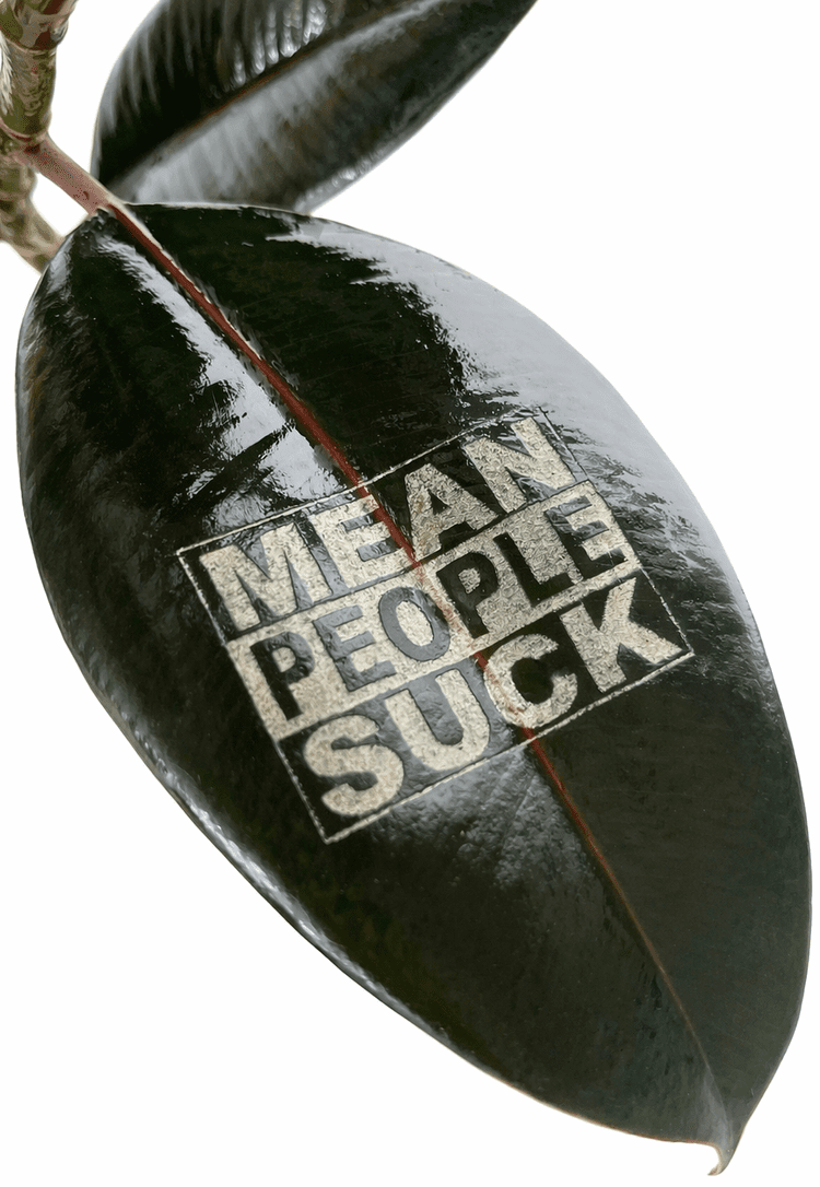 Glossy leaf stamped with MEAT PEOPLE SUCK in bold letters