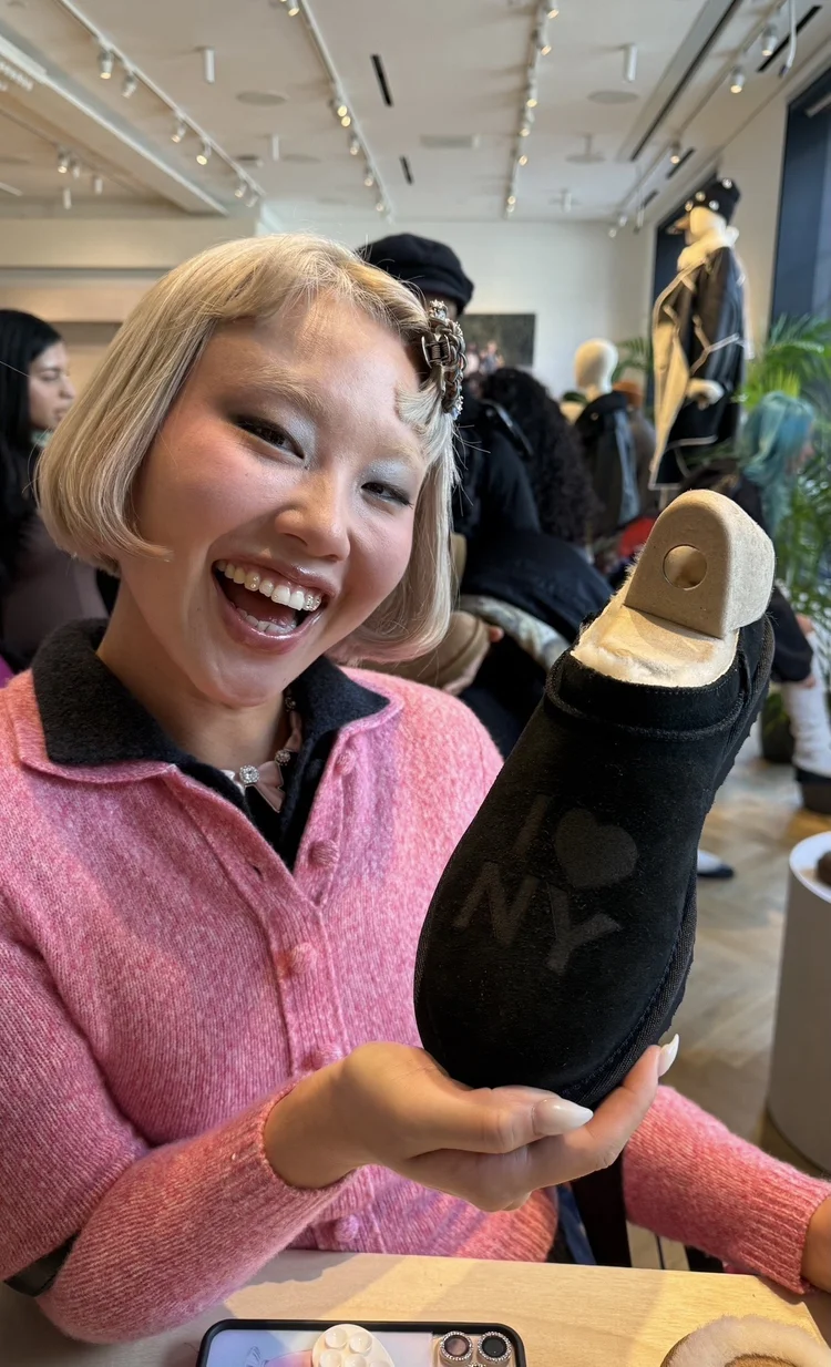 Guest holding her customized UGG shoe at an in-store engraving event