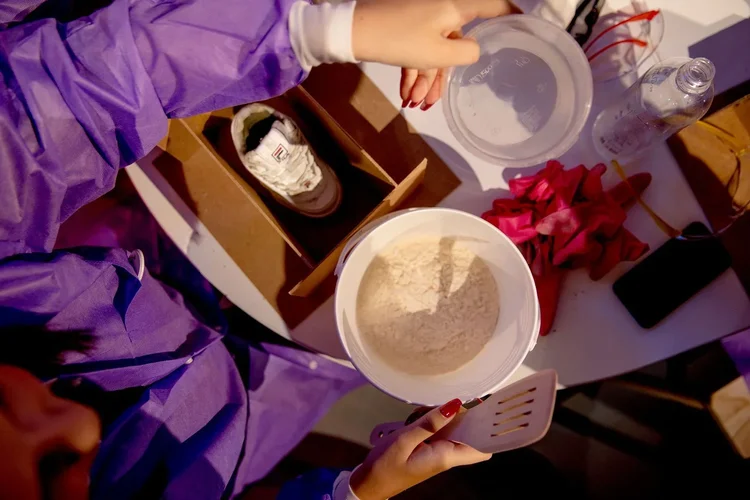 Pouring clay mix into a bowl at the workshop table