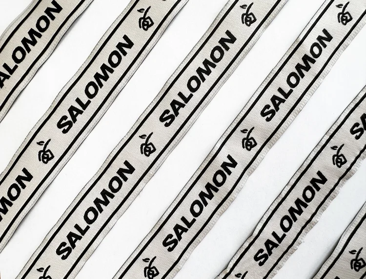 Strips of woven fabric labels with the Salomon wordmark