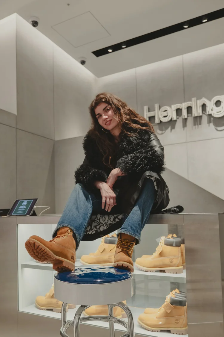 Model in Timberland boots sitting on a store counter