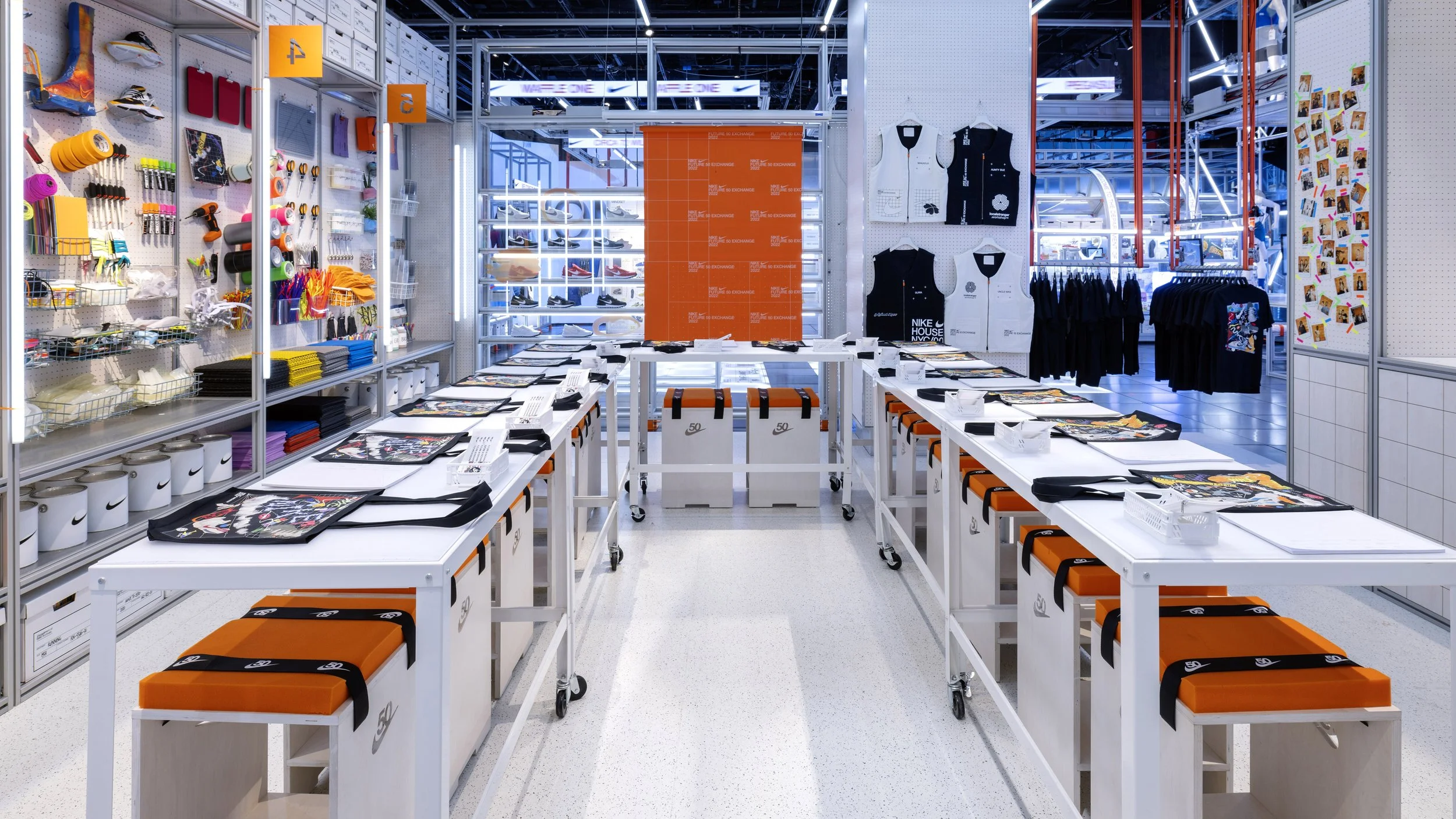 Inside a Nike store with tables displaying merchandise, including bags and clothing, surrounded by shelves with shoes, accessories, and colorful items.