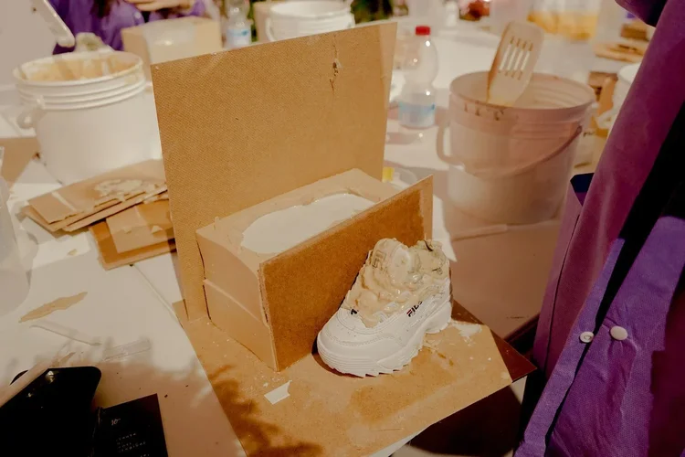 Sneaker sculpted from clay in a cardboard box