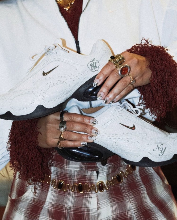 Guest holding customized Nike sneakers with Yankees logo at a live customization event