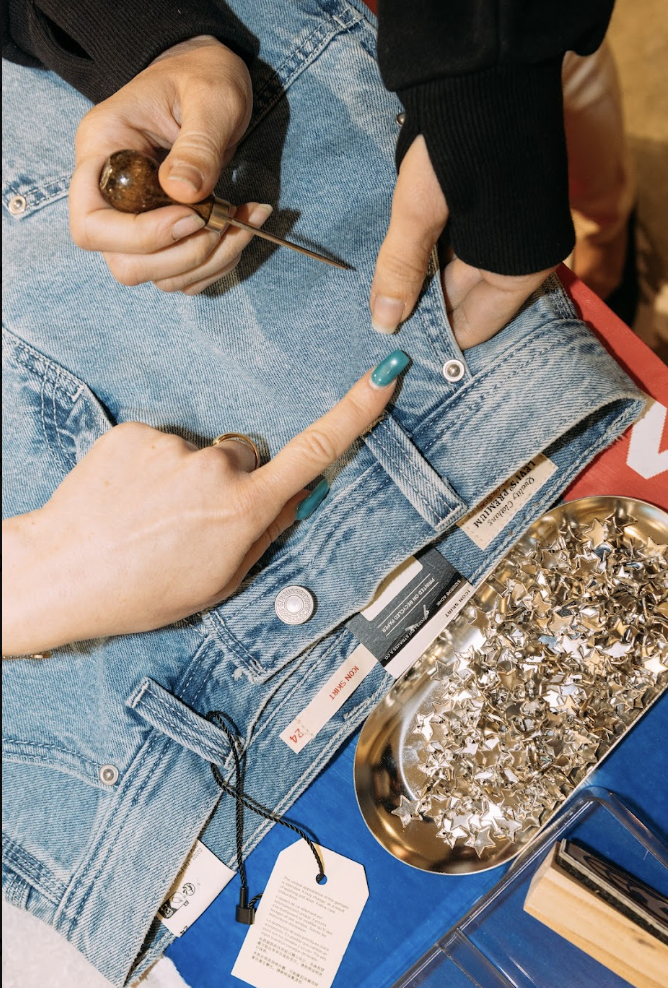 Fixing rhinestones and studs onto denim at a live event