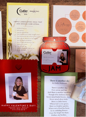 A collection of various cards, including business cards, a Valentine's card, and an Emily Dickinson poem, arranged on a table from Amanda Lucy.