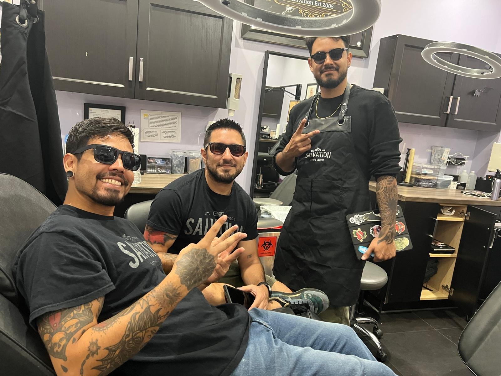 Tattoo school graduates working professionally inside a licensed tattoo shop environment