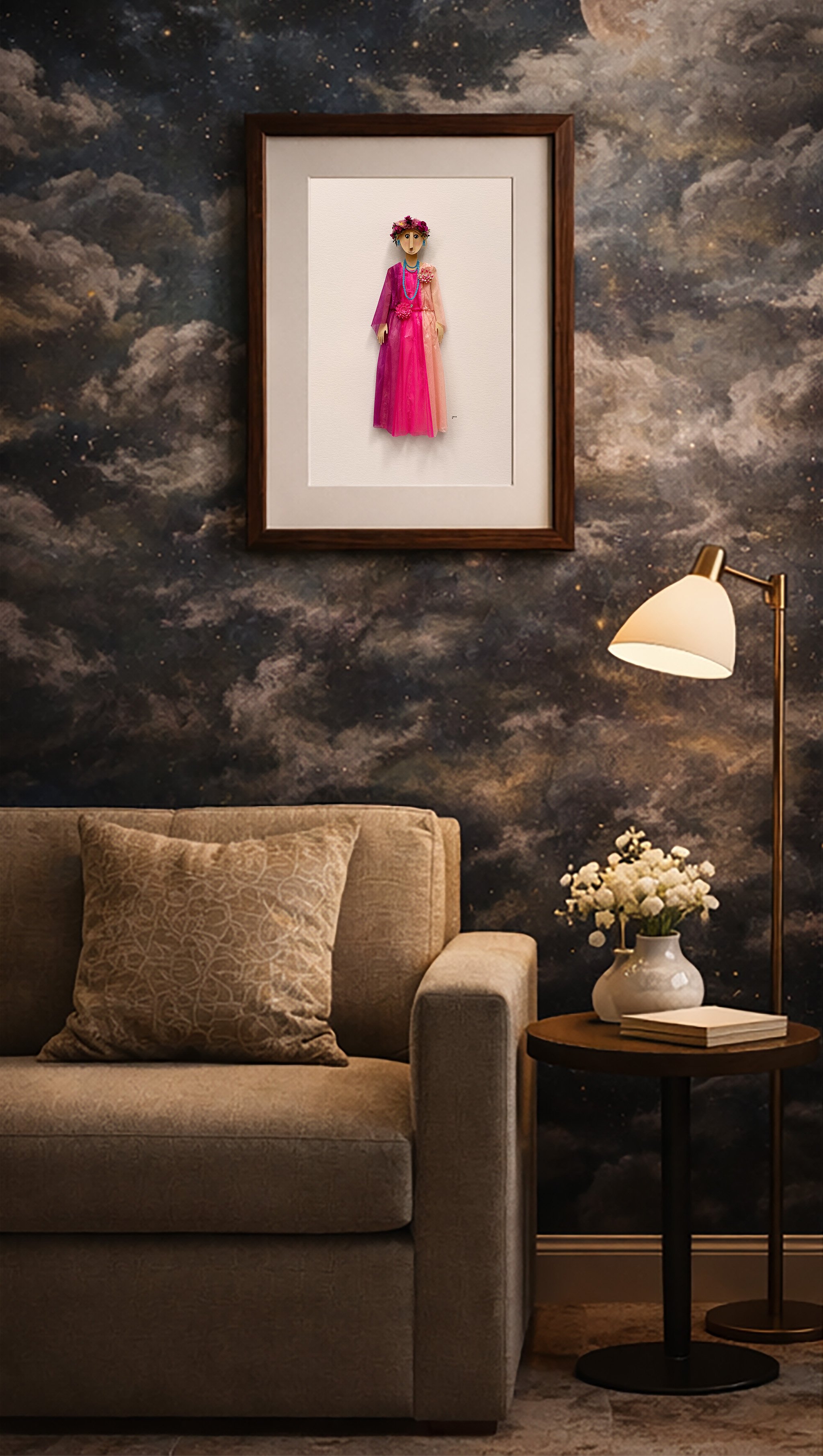 Living room with beige sofa, patterned pillow, side table with white vase and flowers, wall-mounted lamp, and framed custom paper portrait of a girl in a pink dress on a dark, cloud-like wallpaper.