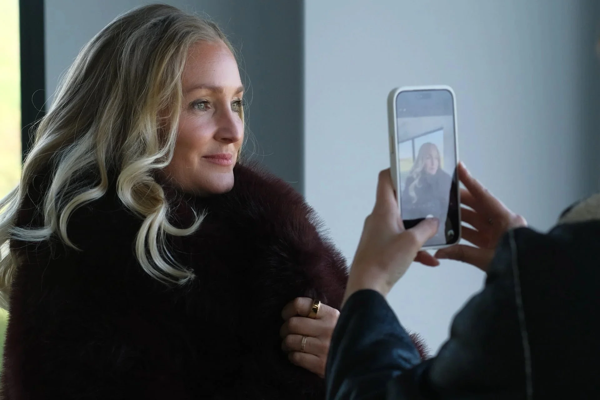Confident woman taking a photo on her phone, representing visibility, self-expression and feminine leadership for high-achieving women in business