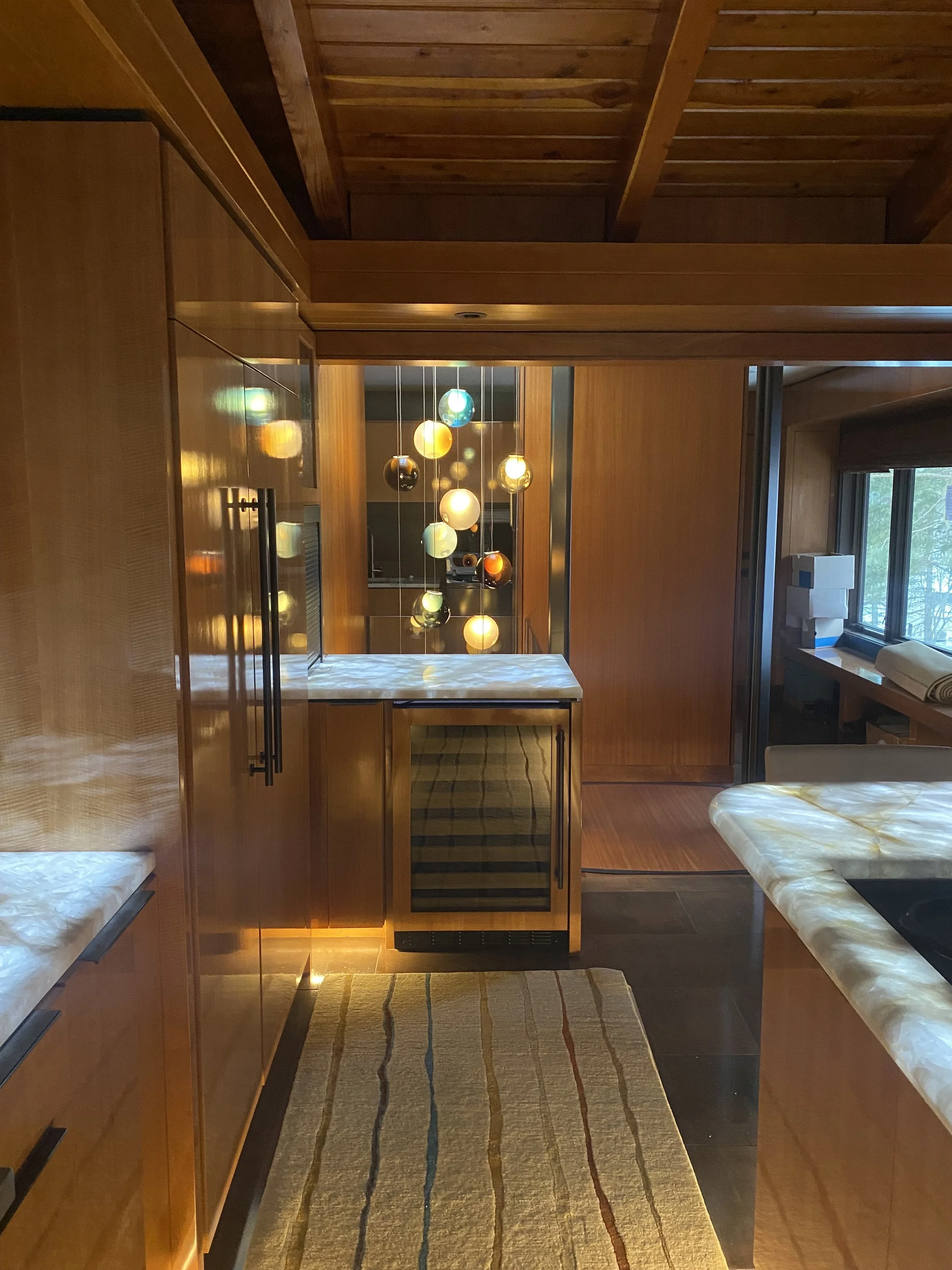 Photo of a Nordea Homes job showing a kitchen with woodgrain finishes and an ornate chandelier