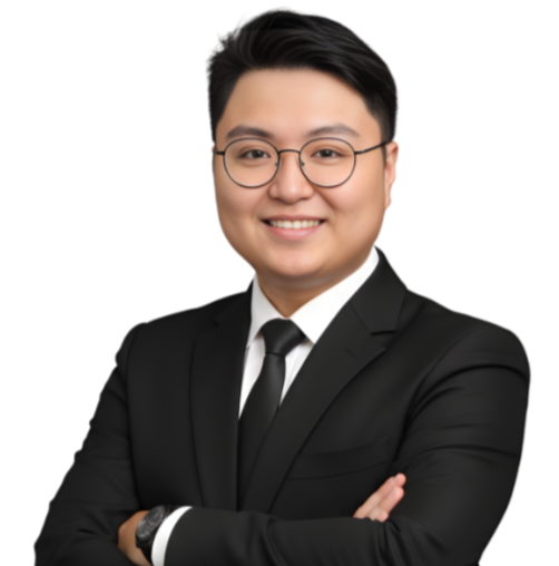 Portrait of a young man in a black suit and eyeglasses smiling with arms crossed.