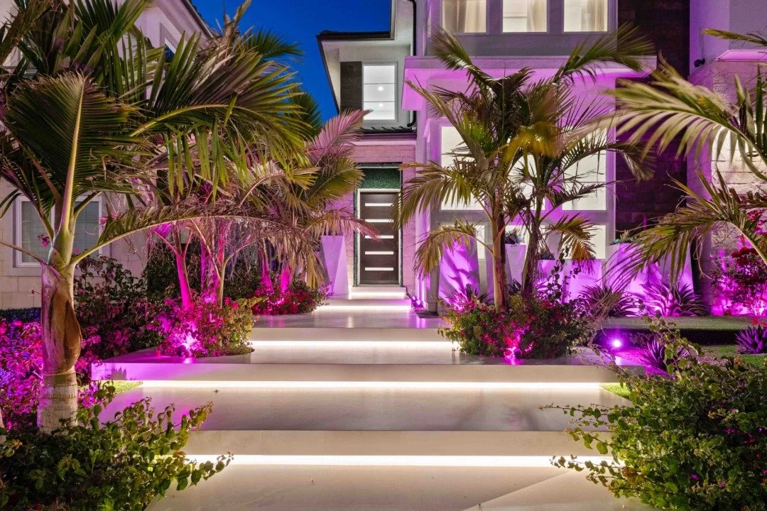 An image of a home surrounded by Palm Trees enveloped in pink light.