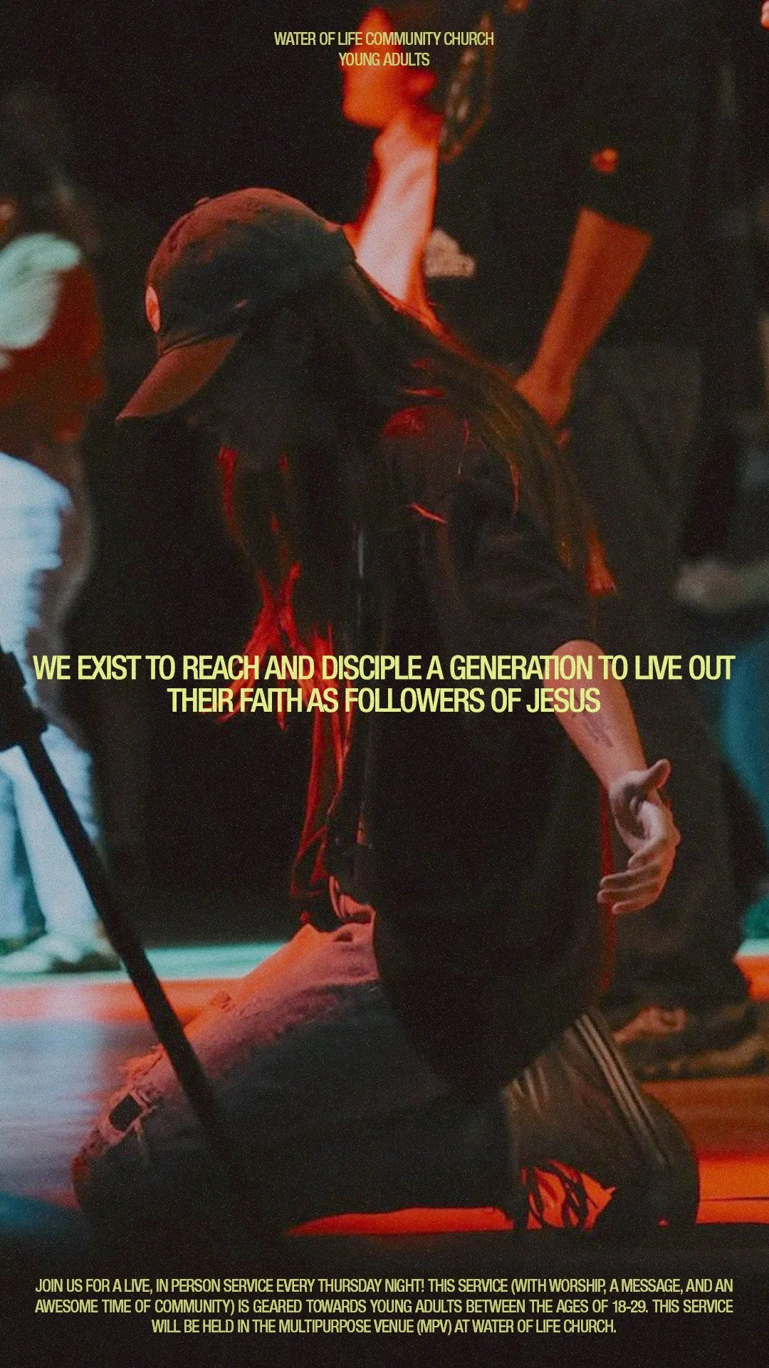 A person kneeling with one hand raised, wearing a black baseball cap and hoodie, during a church event at Water of Life Community Church for young adults, with a message about reaching and discipling a generation to follow Jesus.