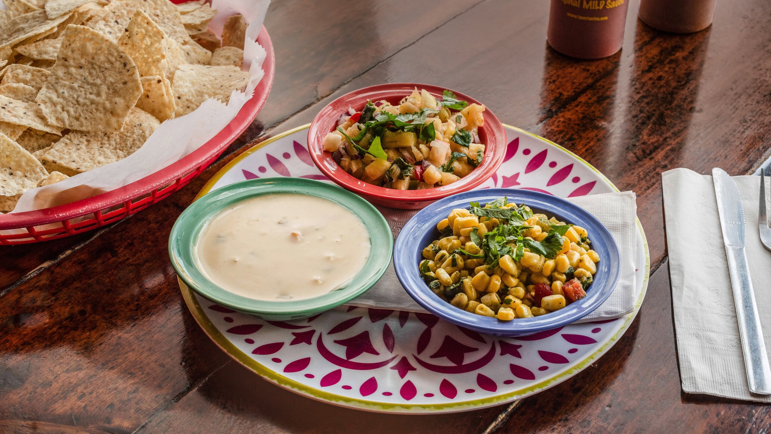 Can't decide on just one dip? Try three! Shown here is our queso, corn salsa, and pico de gallo, served with a big basket of crunchy corn tortilla chips