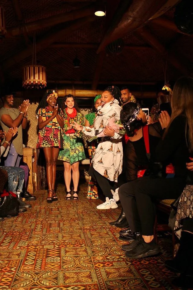 A group of models clap at the end of a runway.