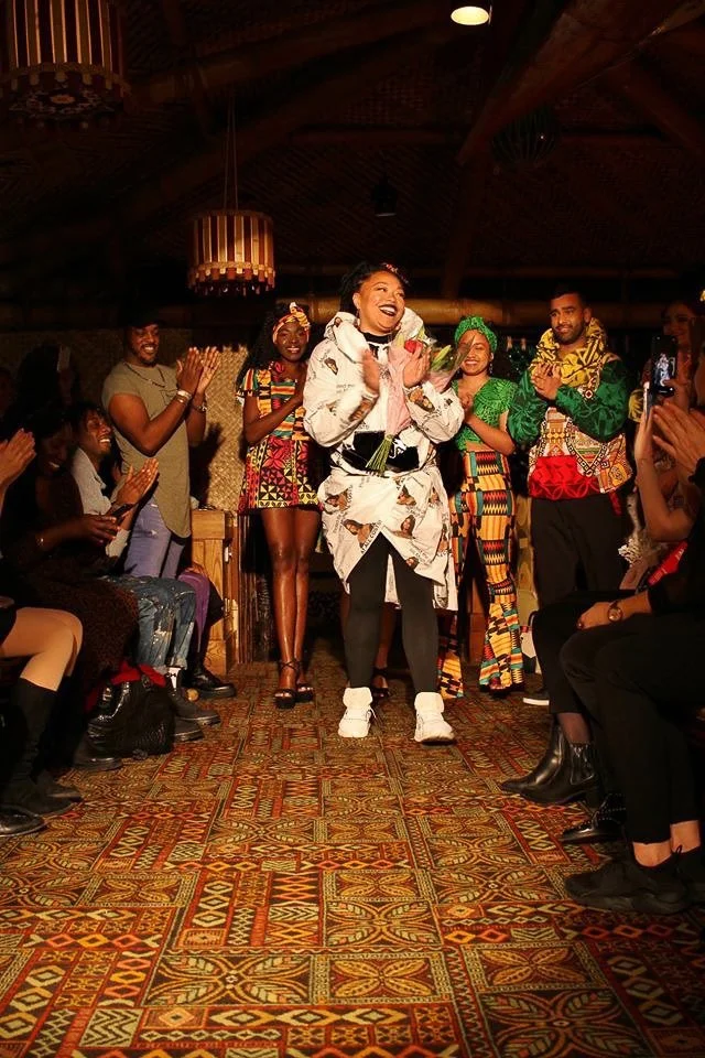 A group of models clap at the end of a runway.