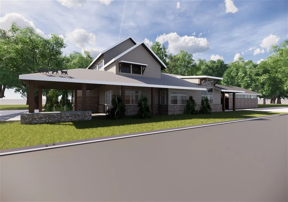 A modern two-story house with a large sloped roof, stone and siding exterior, surrounded by trees and a lawn, with a driveway in the foreground.