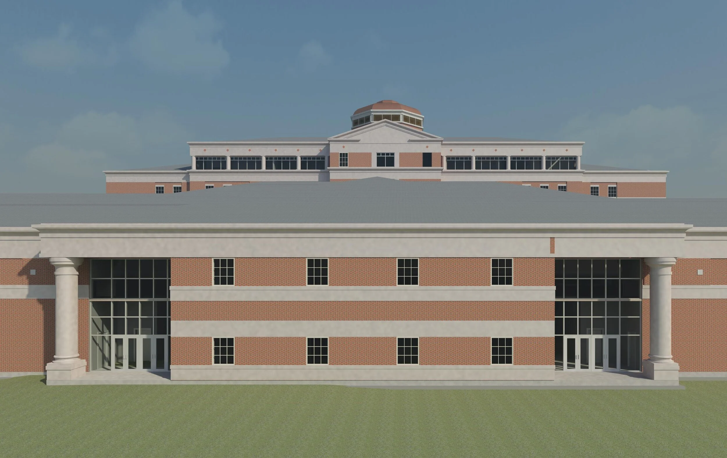 A large brick and concrete building with columns and multiple stories, set against a blue sky with some clouds.