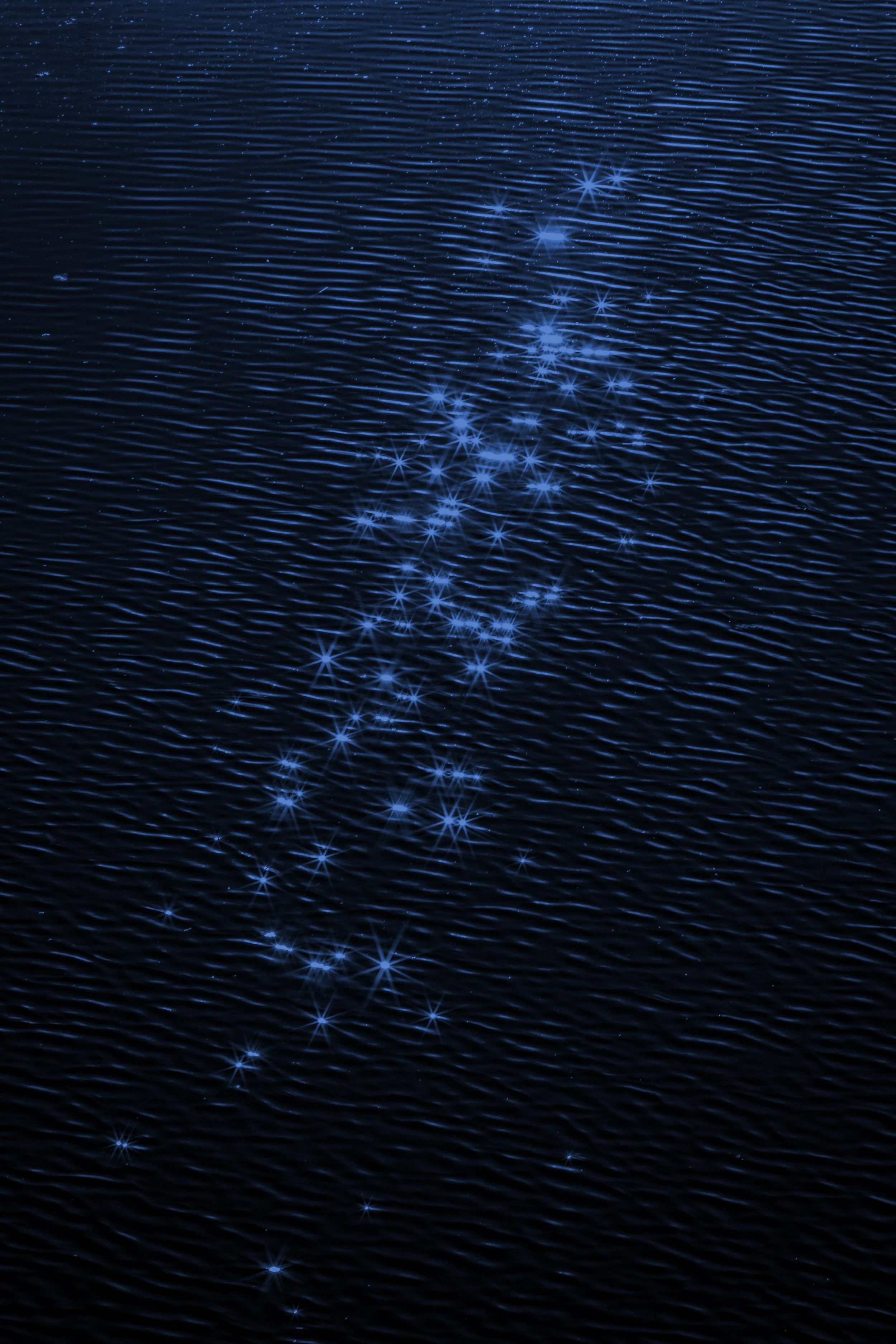 Blue star-shaped sparkles on a dark, rippled water surface.