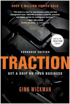 Book cover for 'Traction: Get a Grip on Your Business' by Gino Wickman, featuring a black background with a close-up of typewriter keys and orange and white text.