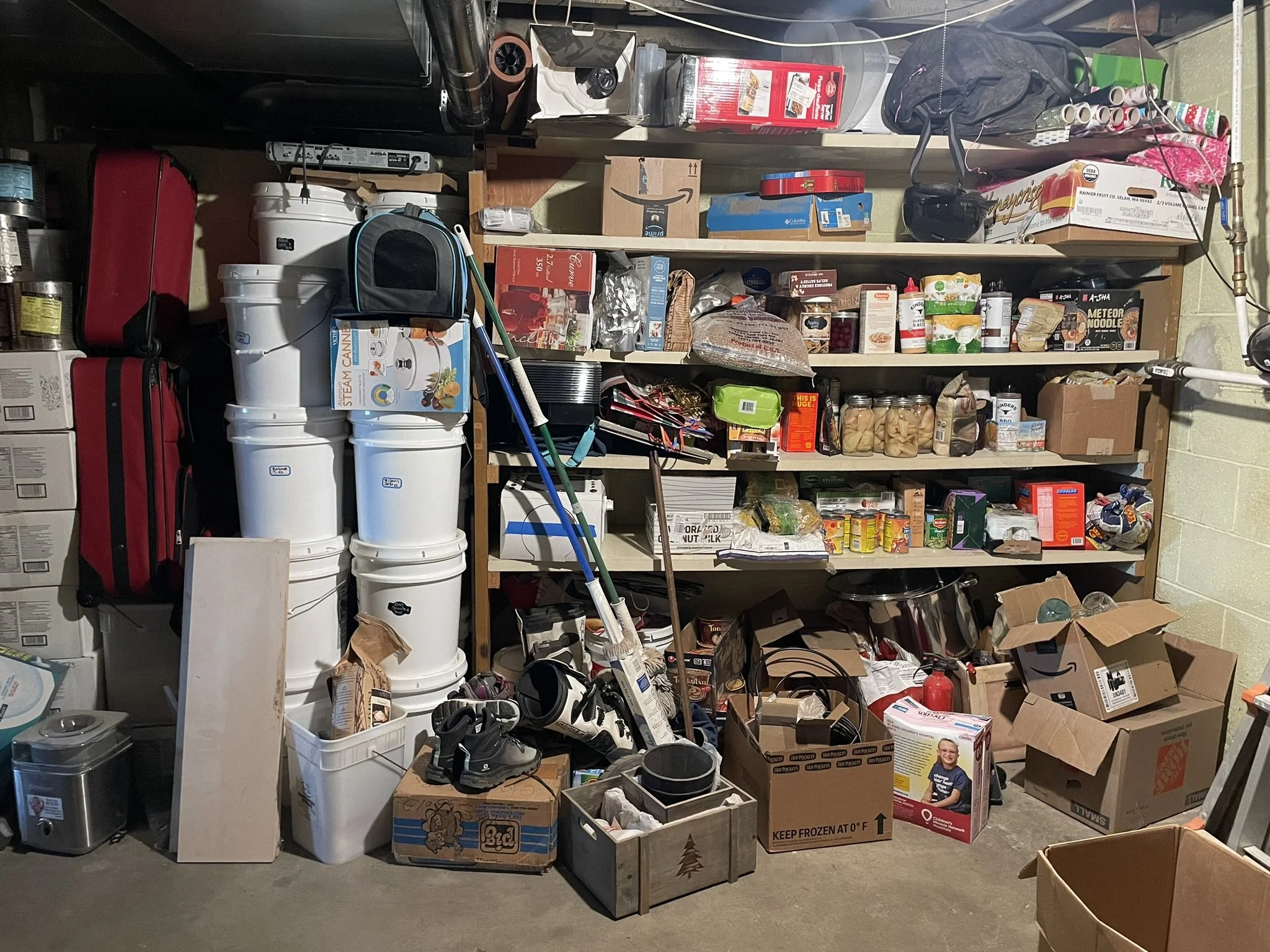 A cluttered garage shelf filled with various household items, food, boxes, and tools.