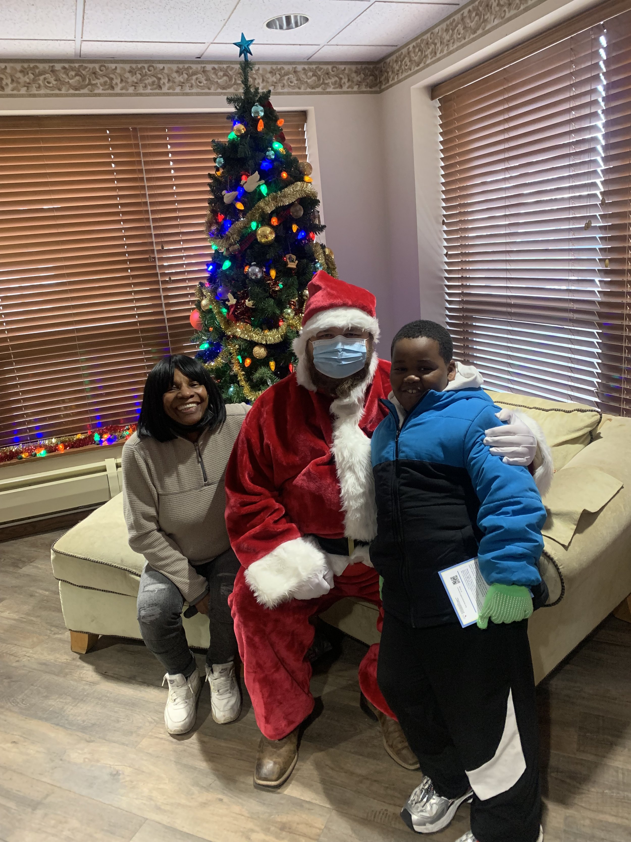 Diana, Santa, and a child wearing a puffy winter coat