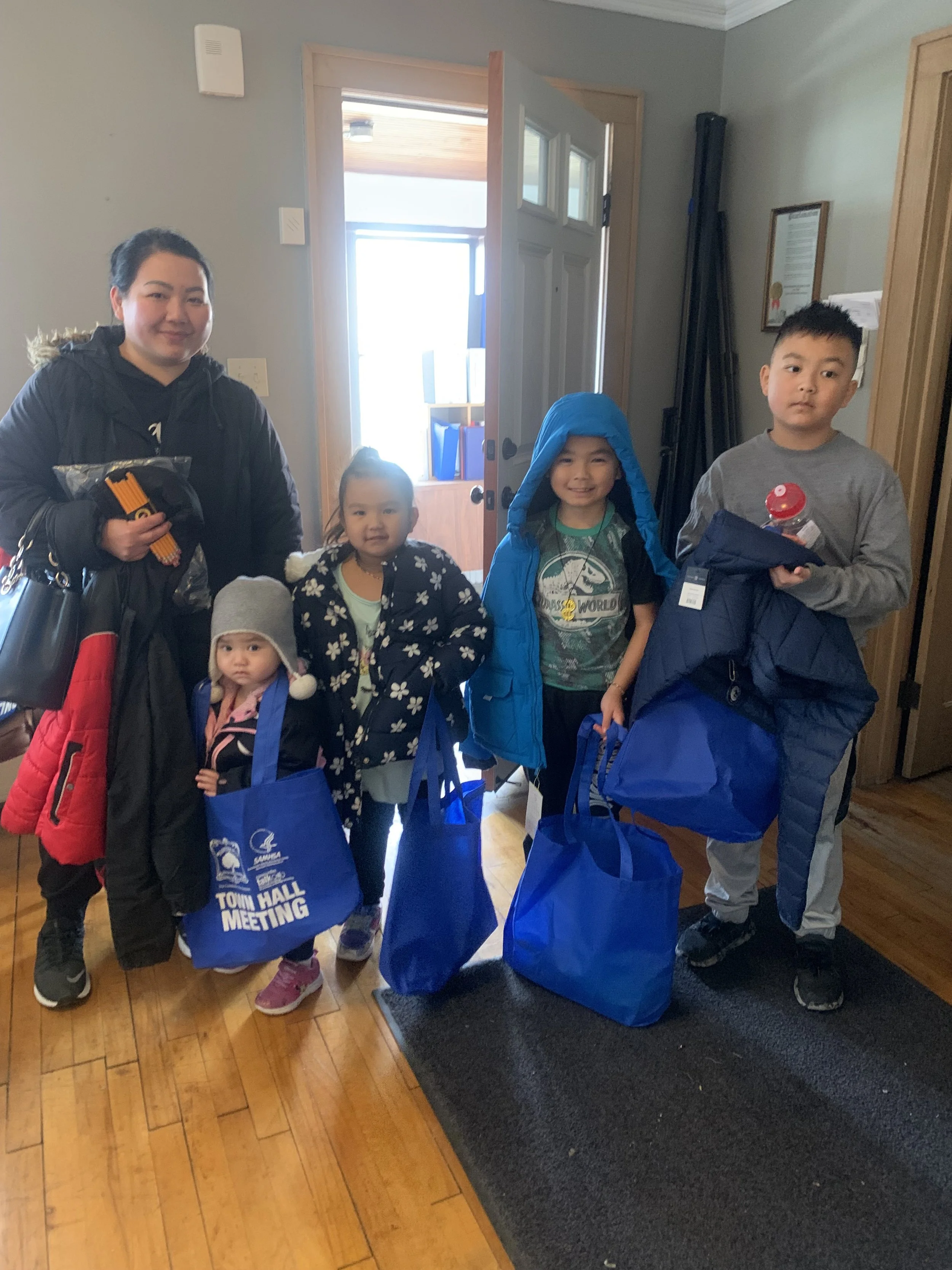 A cute family holding bags and smiling