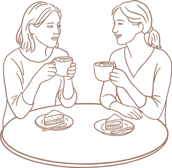 Two women sitting at a round table, each holding a mug, with slices of cake on plates in front of them, enjoying a conversation and coffee.