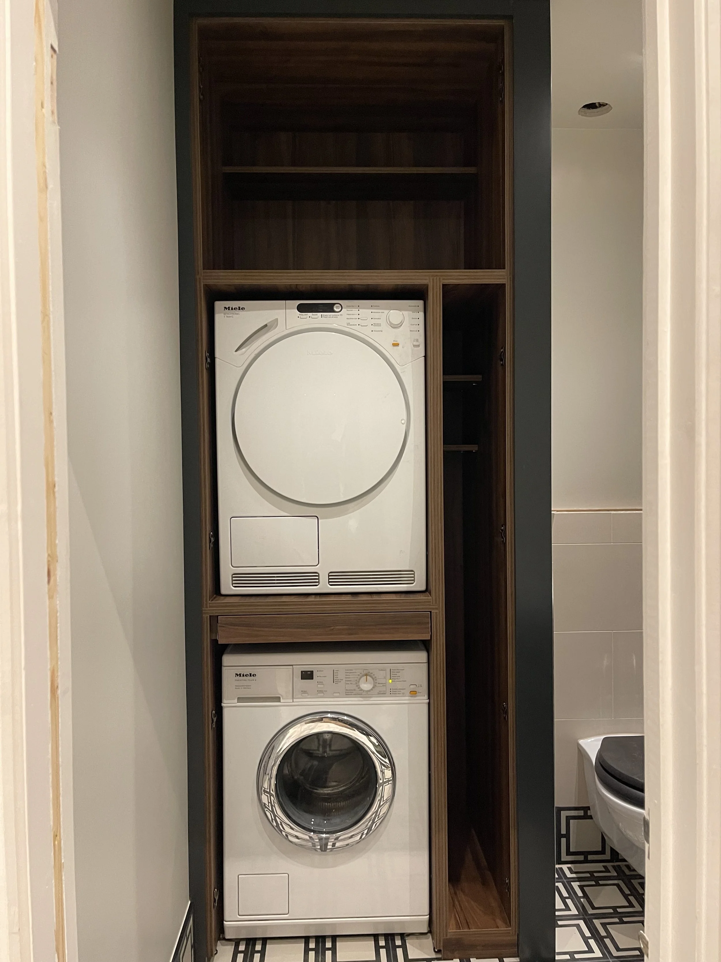 Stacked washing machine utility cupboard .