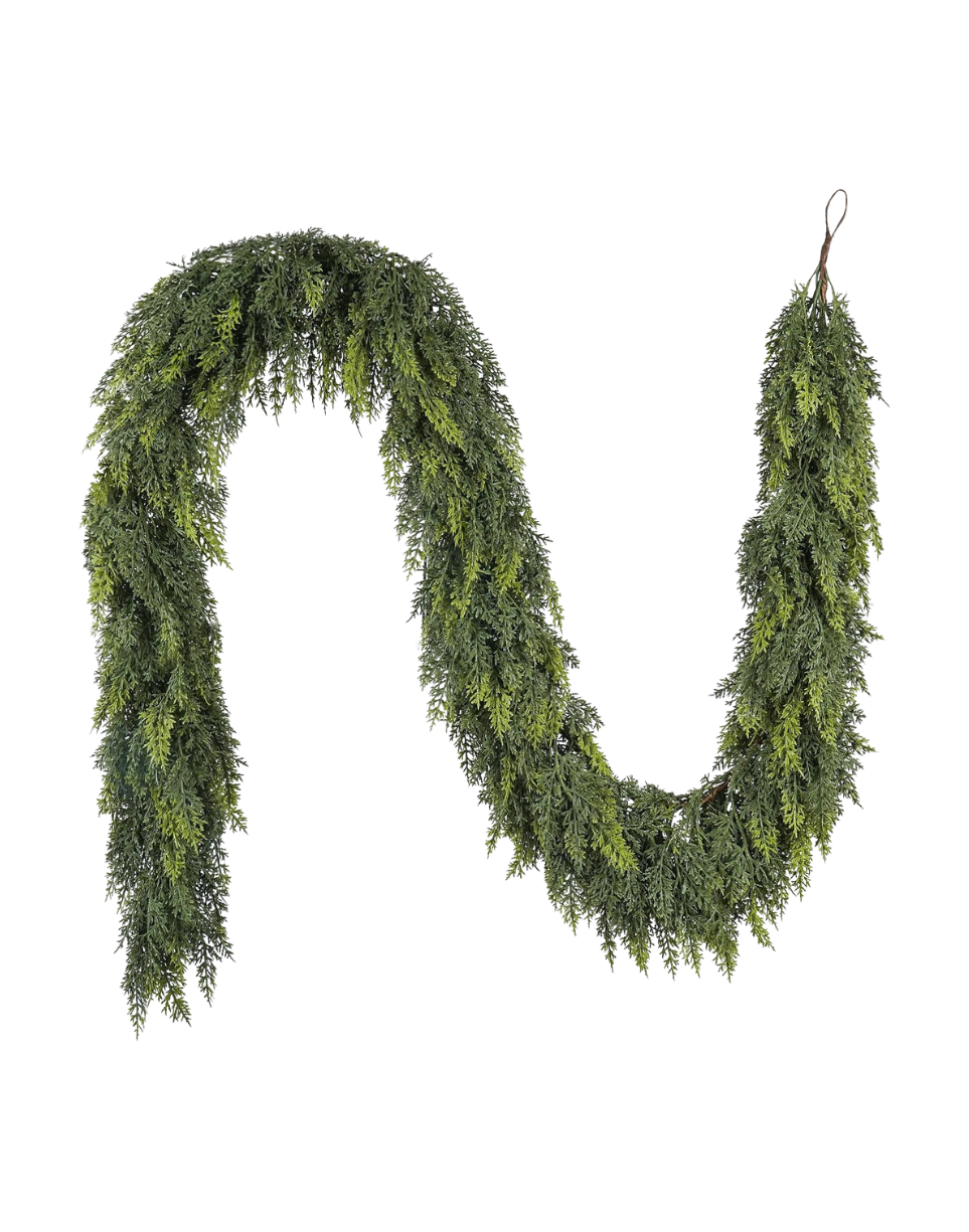 A Christmas wreath made of evergreen branches hung on a wall.