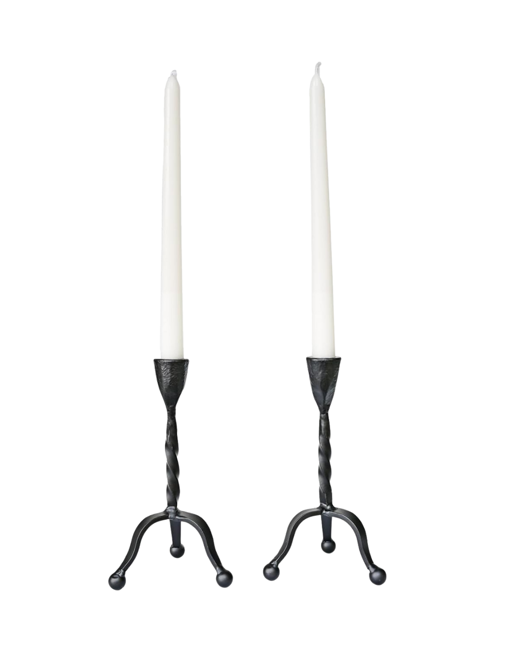 Two white taper candles in black holders with curved bases.