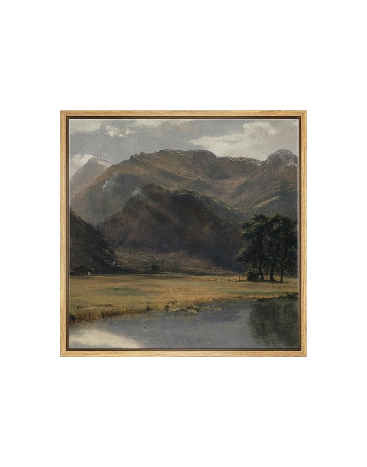 A landscape painting of mountains, trees, a grassy meadow, and a lake, framed in wood.