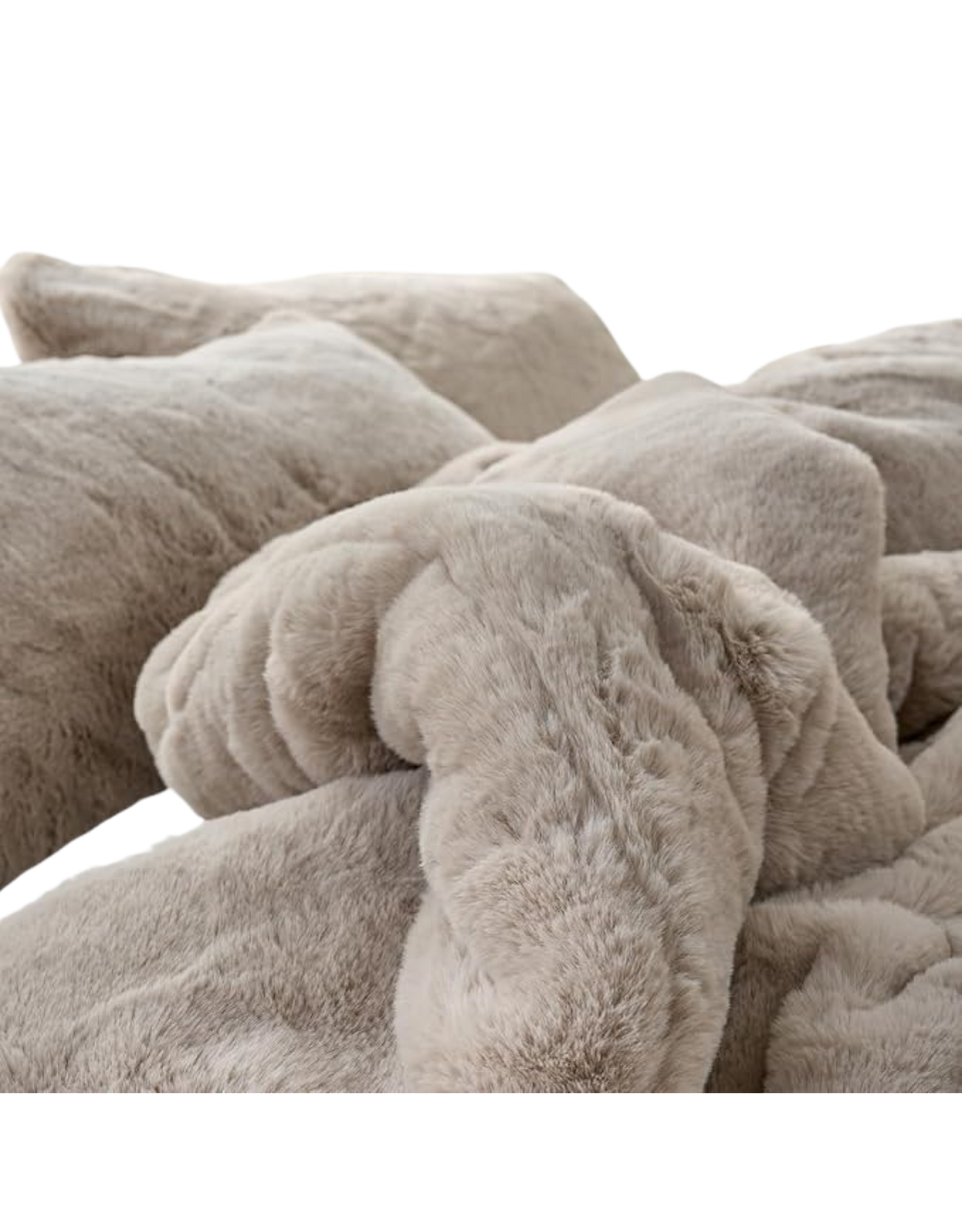 Close-up of a pile of beige, fluffy dog beds or cushions in a soft fabric.