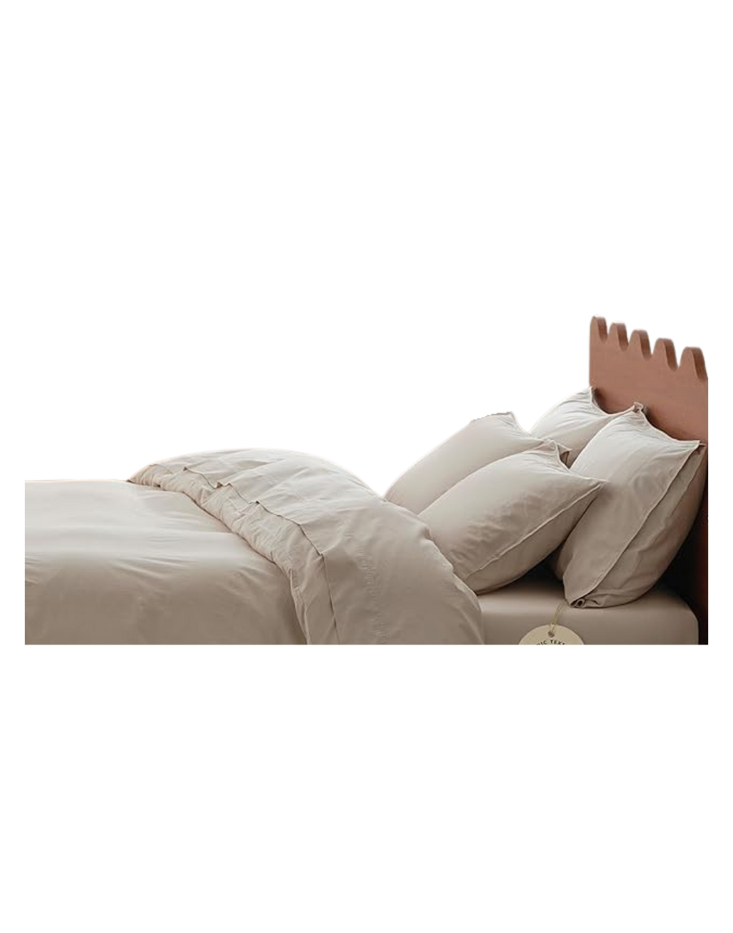 A bed with a tan, scalloped headboard, made up with white sheets, pillows, and a comforter.