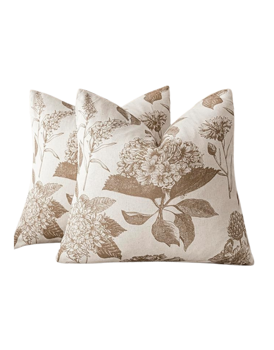 Two decorative pillows with a beige floral pattern on a white background.
